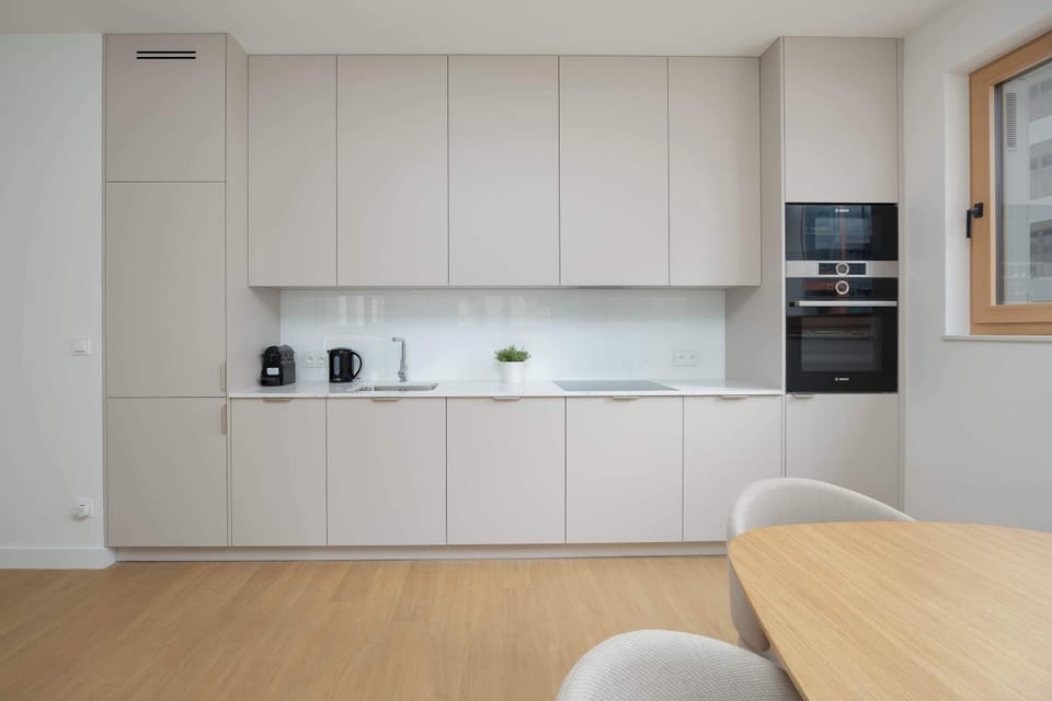 A modern kitchen with built-in cabinets and clean, minimalist finishes. The layout offers both functionality and visual harmony.