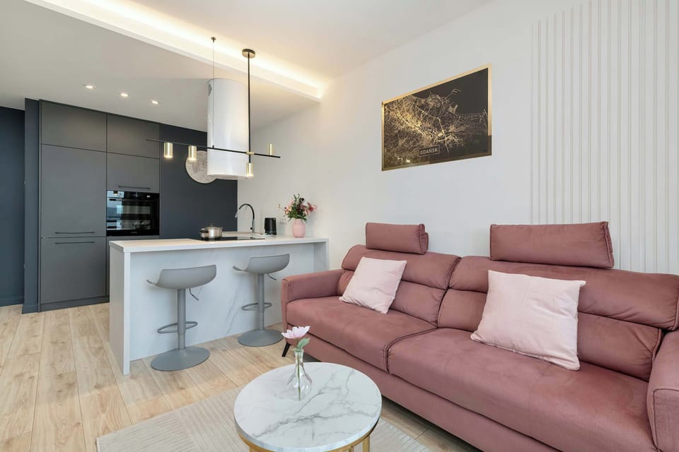 Inviting lounge with rose-toned sofas and a gold-accented side table.