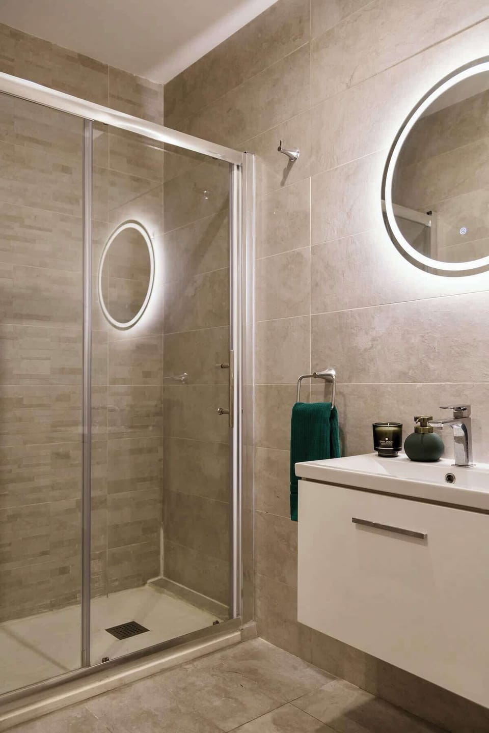 The second bathroom offers a fresh, modern finish with a spacious shower and soft lighting.