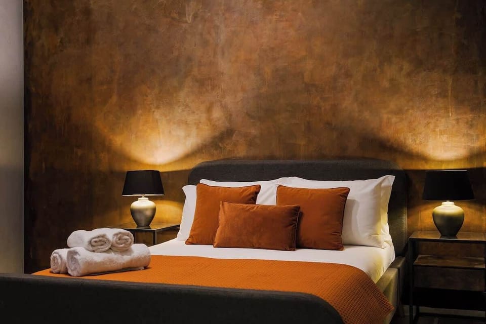 This boutique-style double bedroom stands out with its rich copper tones and warm lighting. Perfect for a restful night or a quiet afternoon nap.