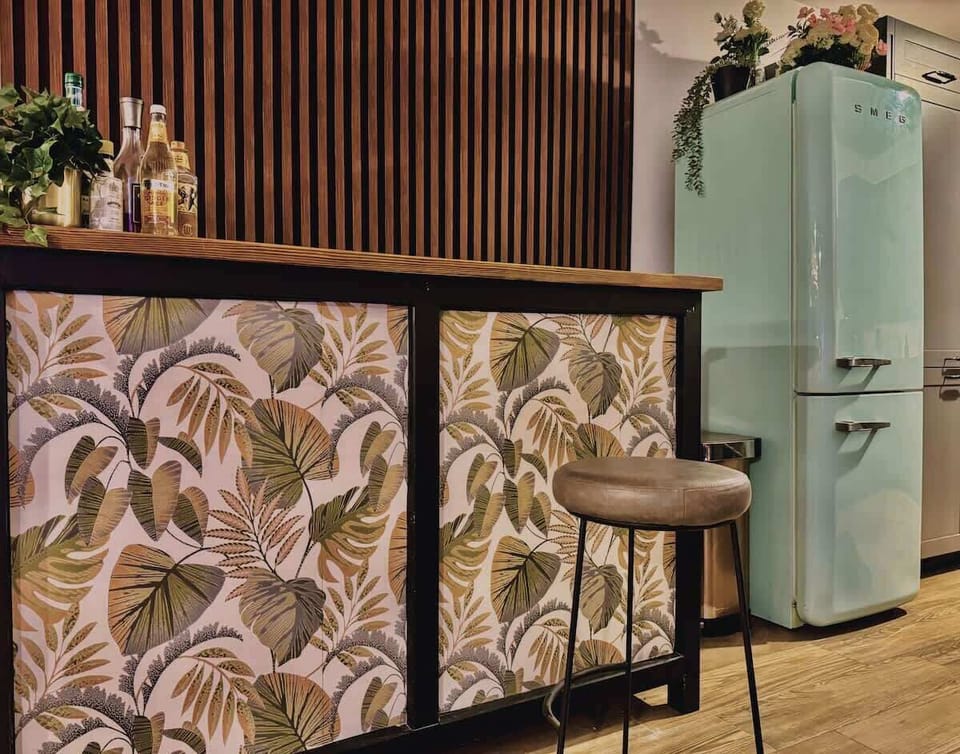 Cook in style with a kitchen that blends functionality and design—featuring bold tropical accents, a retro Smeg fridge, and thoughtful touches to inspire your culinary creativity.