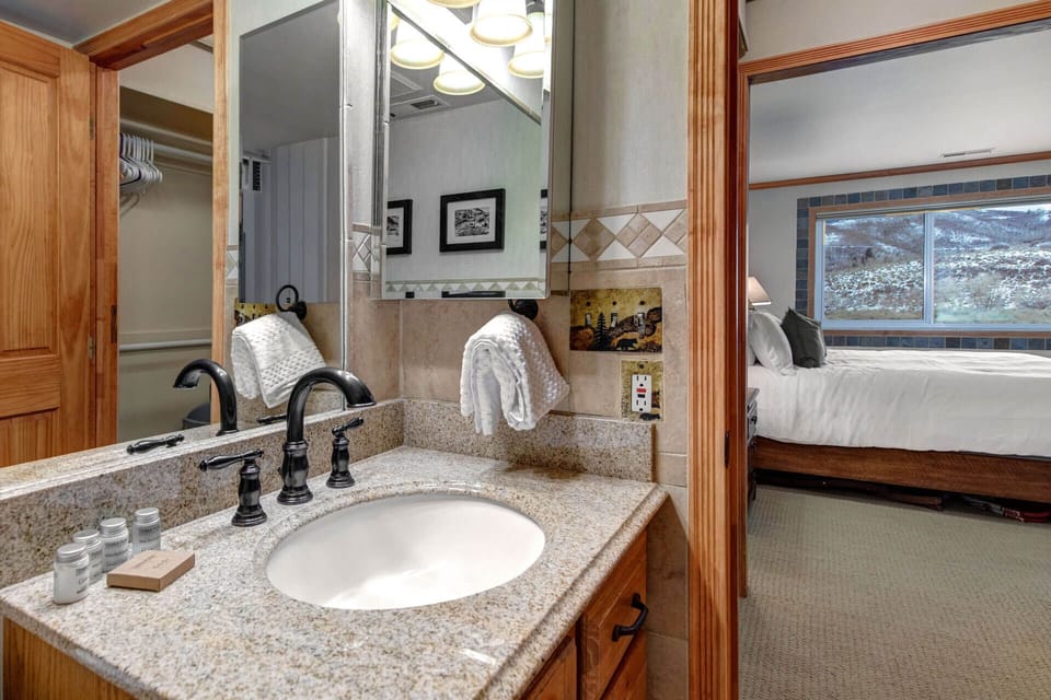 Your private bathroom features a granite vanity, soft towels, and welcoming mountain views—refreshing mornings and relaxing evenings start here.