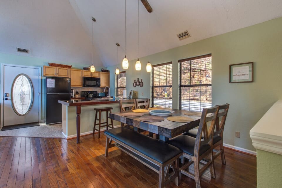 Gather around your rustic dining table beneath warm pendant lights, with the full kitchen just steps away for easy meal prep.