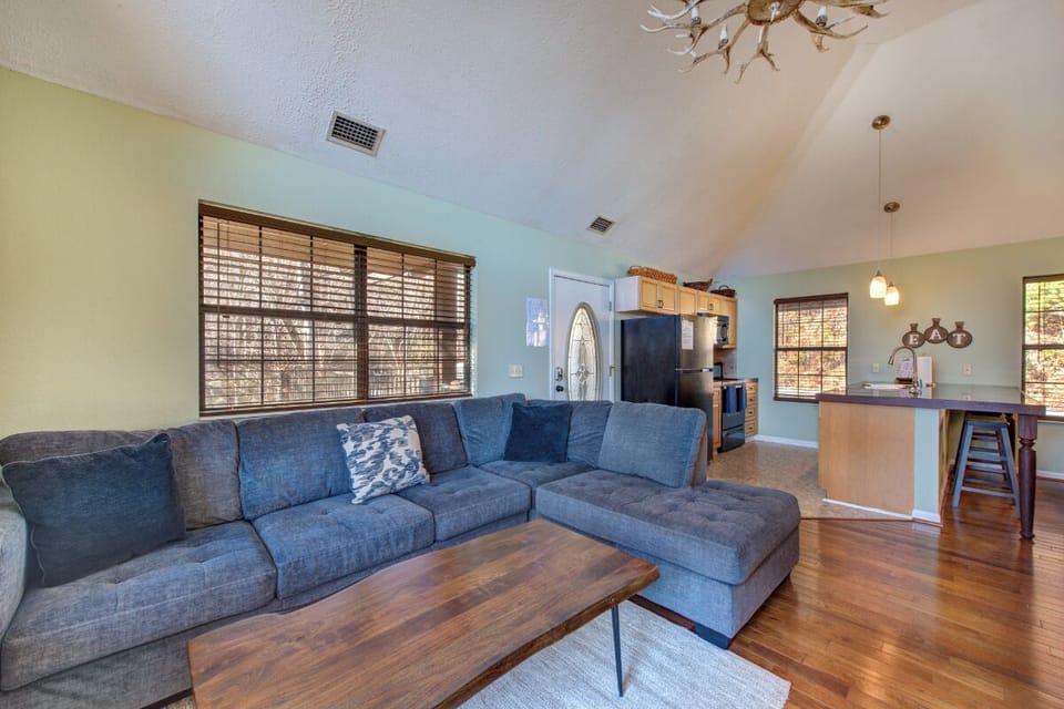 Sink into the plush sectional sofa and enjoy your open-concept living space with gleaming hardwood floors and natural light streaming through bamboo blinds.