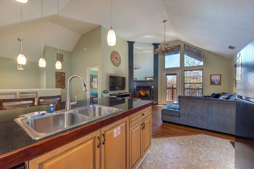 Your open-concept space flows from granite-topped kitchen to cozy living area with crackling fireplace and mountain views.