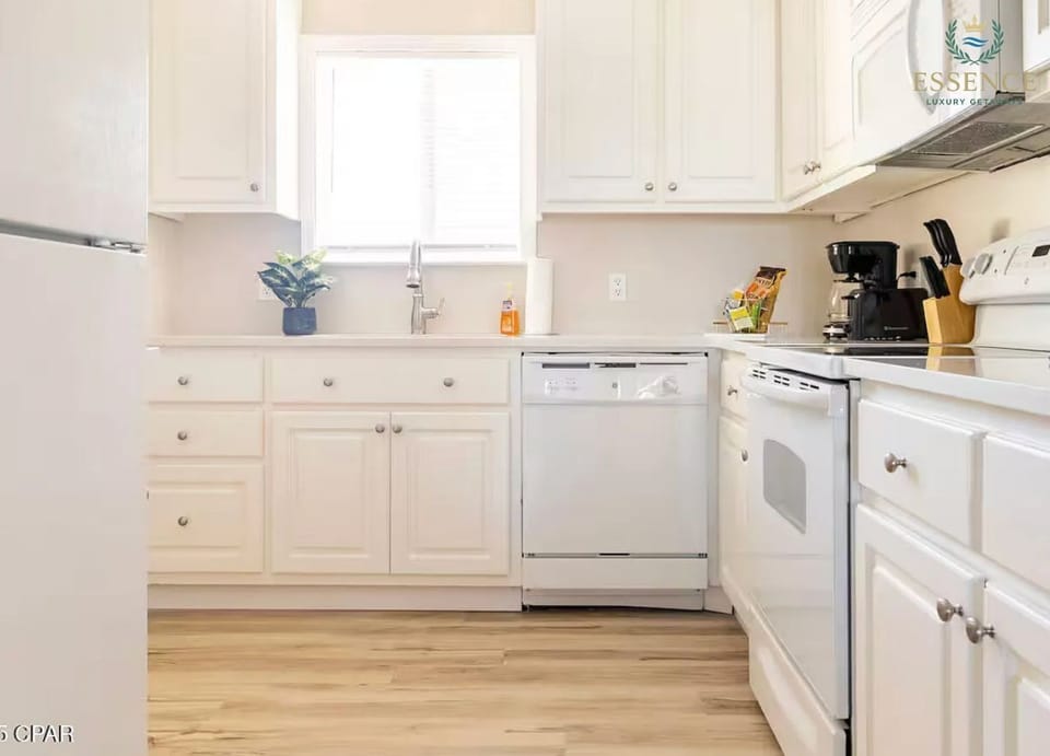 Bright, fully equipped kitchen with white cabinetry, spacious countertops,