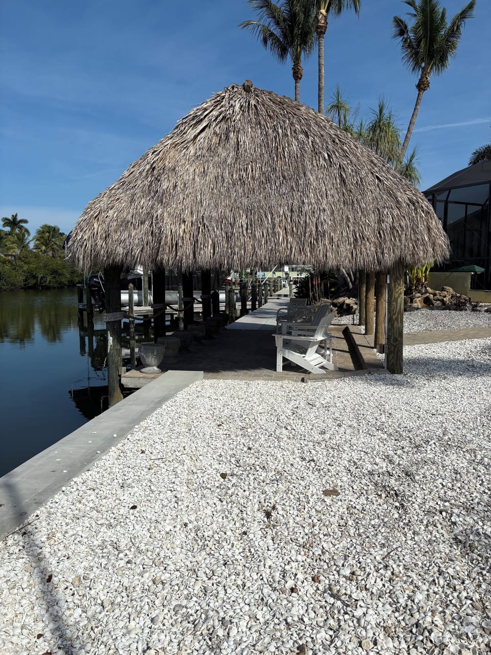 Cozy tiki hut with thatched roof, warm lighting, and tropical vibes by the shore