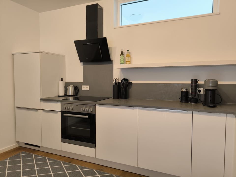 Küche mit Vollausstattung: Alles steht bereit zum Kochen: Wasserkocher, Kaffeemaschine mit Kapseln, Essig & Öl, Salz & Pfeffer und viel mehr.
