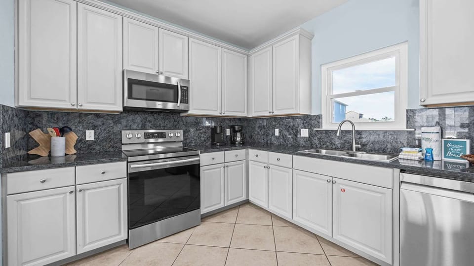 Stylish kitchen with stainless steel appliances and complete cooking gear.