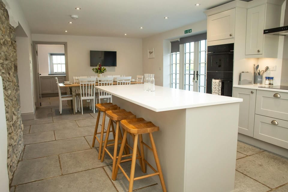Kitchen breaksfast bar with stools, oven, dining area with table and chairs