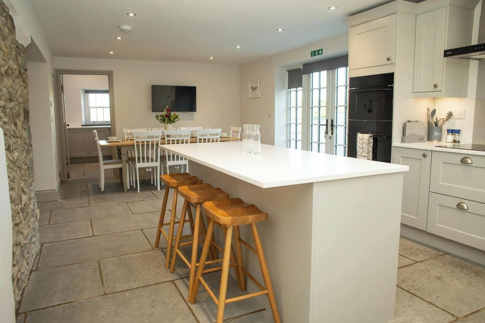 Kitchen breaksfast bar with stools, oven, dining area with table and chairs