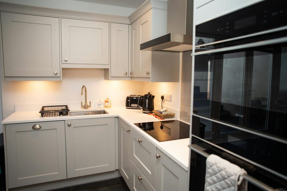 Kitchen with oven, microwave, hob, sink, kettle and toaster