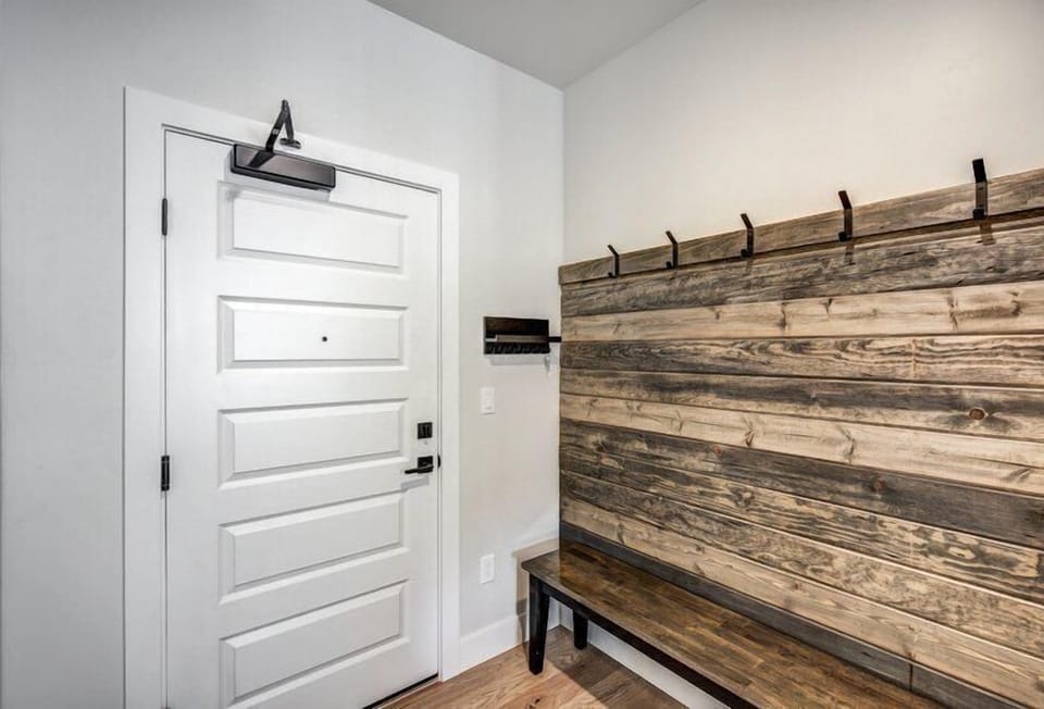 Functional entryway designed with a wooden bench and hooks, perfect for a quick and organized entry after outdoor adventures.