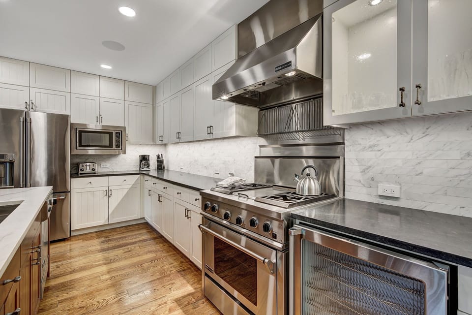 Immerse yourself in culinary luxury with state-of-the-art appliances and sleek cabinetry, all set against a backdrop of exquisite marble and warm hardwood floors.