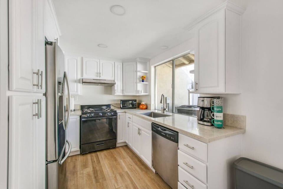 Fully equipped kitchen with modern appliances and coffee maker.