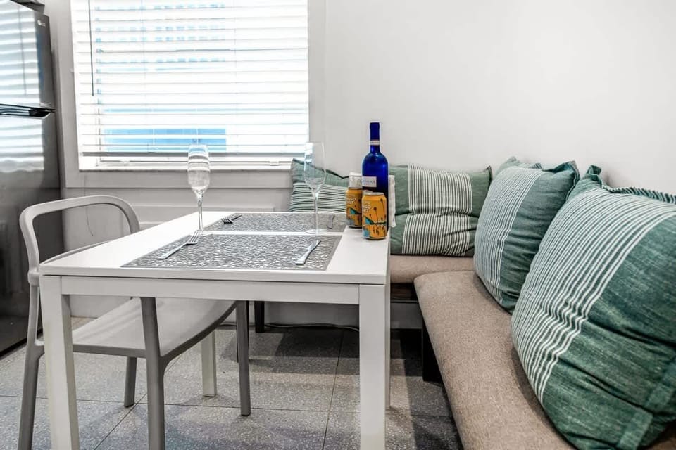 "Start your morning in this bright dining nook! Features a sleek table and comfortable seating, perfect as a dedicated workspace for digital nomads. A clean, functional spot in your modern vacation rental. ☕💻"