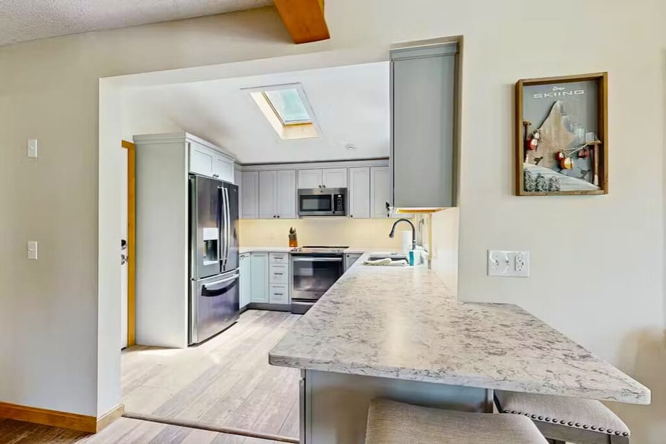 Modern kitchen with stainless appliances and skylight—your perfect cookspace
