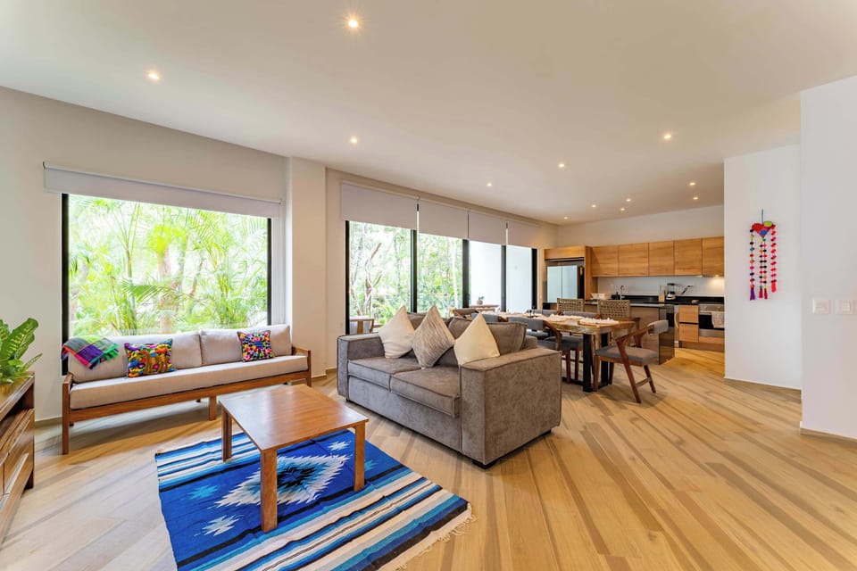 Living Room | Second sitting area with jungle views and a vibrant blue rug.