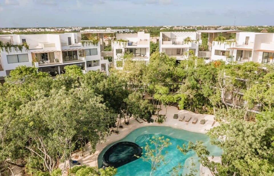 Aerial View | Panoramic look at the pool and condominium surrounded by greenery