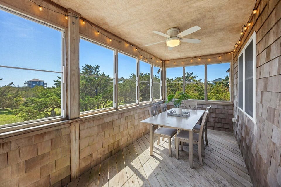 The screened-in porch offers a breezy, shaded space to enjoy the outdoors without the insects.