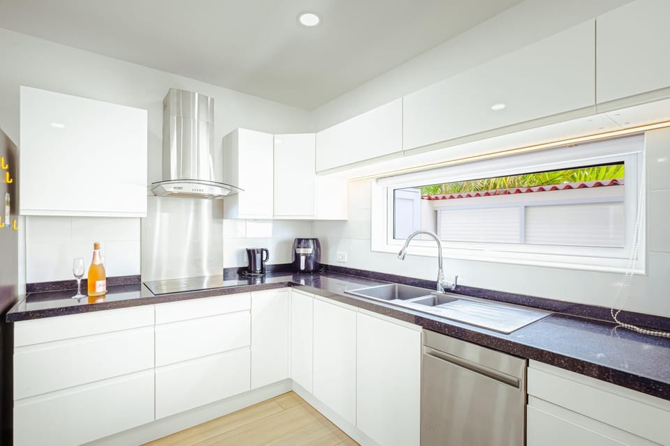 Start your morning in this sun-drenched, white-glove kitchen. The large horizontal window provides a stunning view of lush greenery, blurring the lines between indoors and out. It’s the perfect place to brew your morning coffee and plan your day.