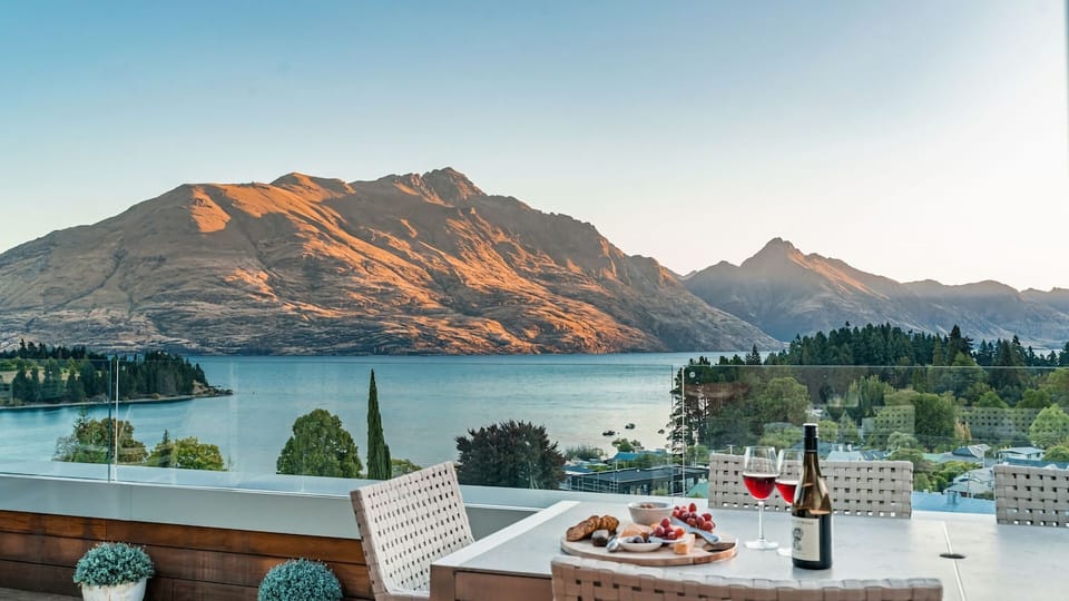 Expansive outdoor balcony with dining table, outdoor heaters, hanging chair, and incredible lake and mountain views. 