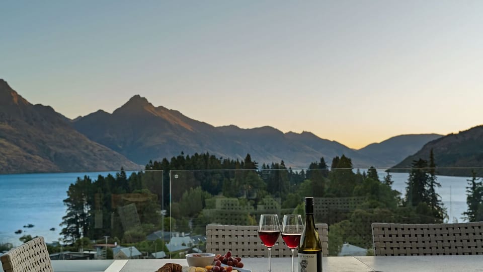 Expansive outdoor balcony with dining table, outdoor heaters, hanging chair, and incredible lake and mountain views. 
