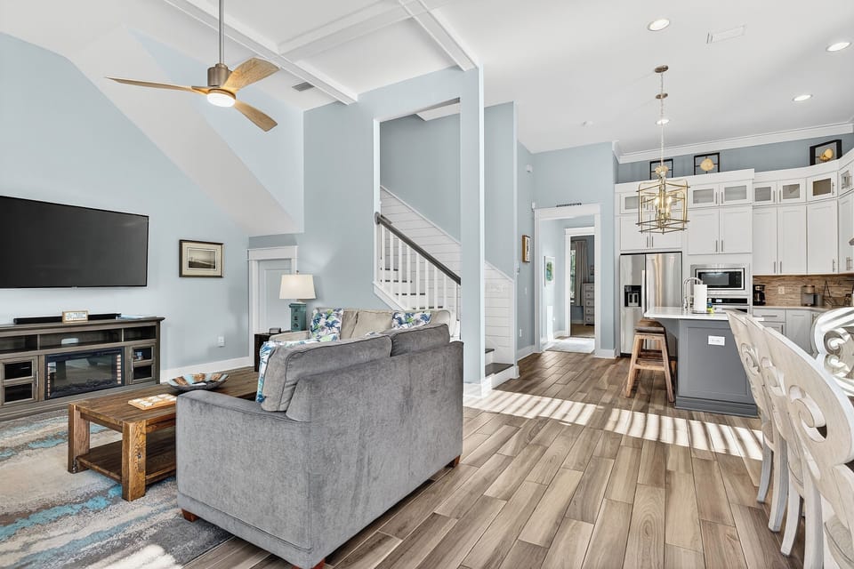 Inviting living room featuring airy coastal design and seamless flow into the kitchen.