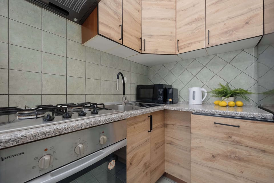 view of the kitchen shows modern cabinets and appliances. It forms a practical and visually appealing cooking area.