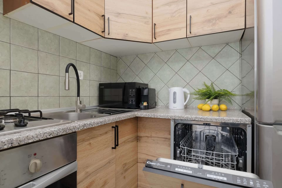 The fully equipped kitchen includes modern appliances and ample counter space. Wooden cabinets bring warmth to the interior.