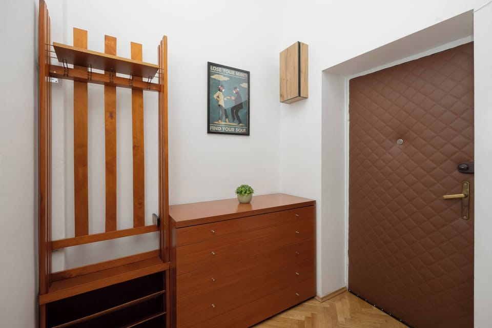 The entrance to the apartment with wooden built-in storage creates an elegant first impression. The area is clean and well-lit.