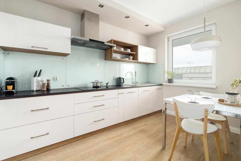 Streamlined kitchenette showcasing white cabinetry, pale timber surfaces, and a clean contemporary layout.