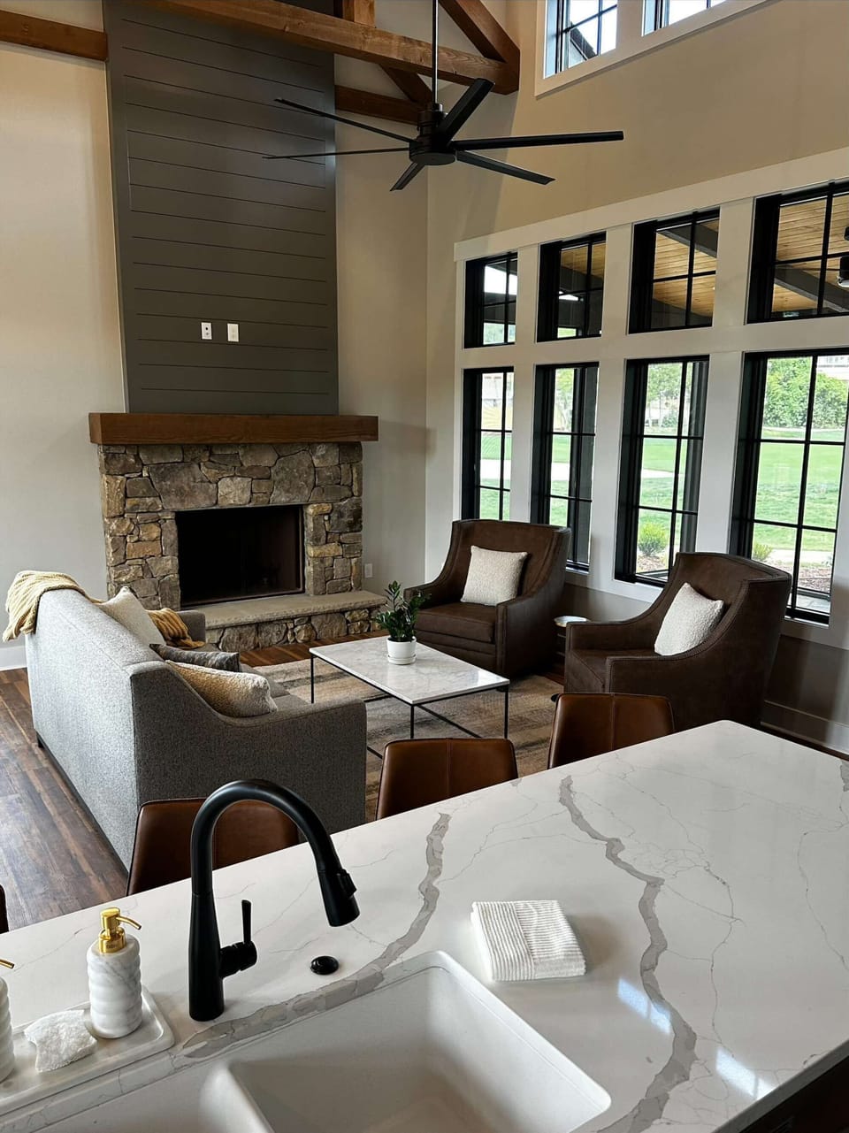 Cozy living area with stone fireplace and tall windows