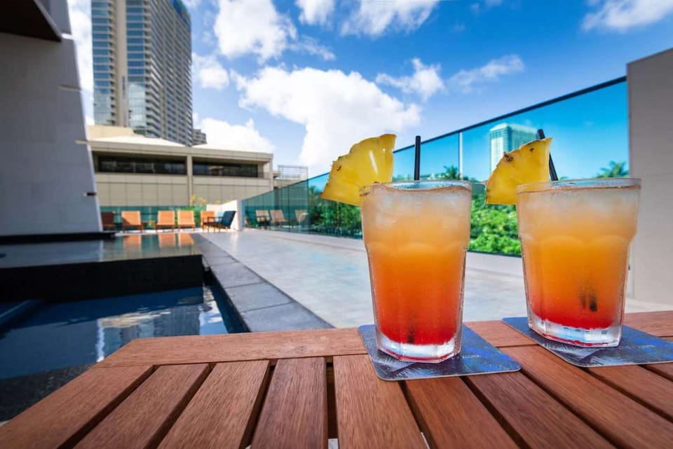 Two tropical drinks on a table beside the outdoor pool