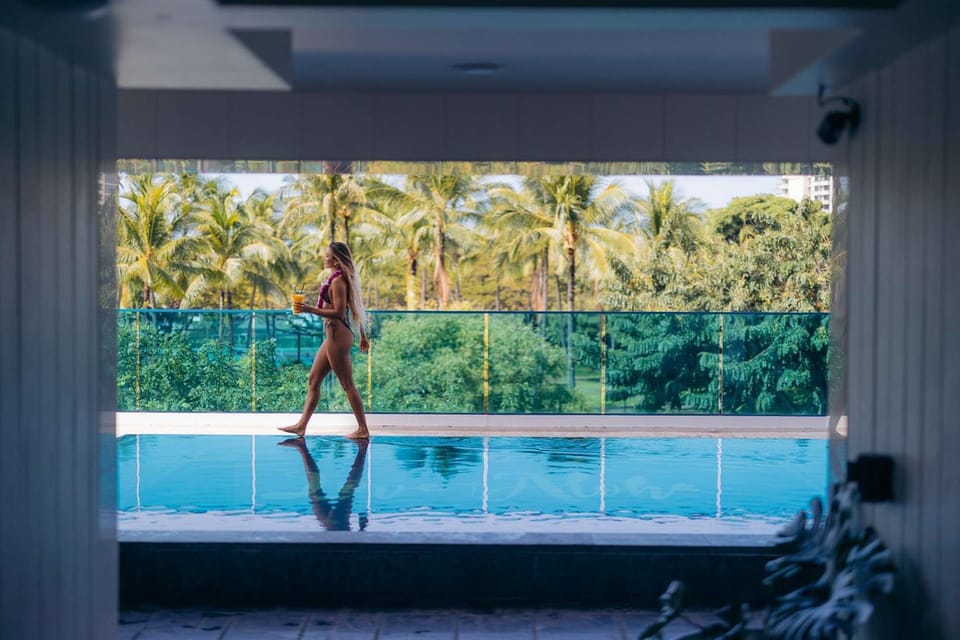 Guest walking by the pool with palm trees in the background
