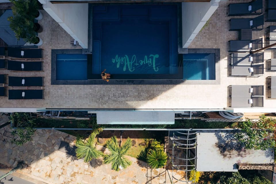 Aerial view of pool deck with lounge chairs and tropical plants