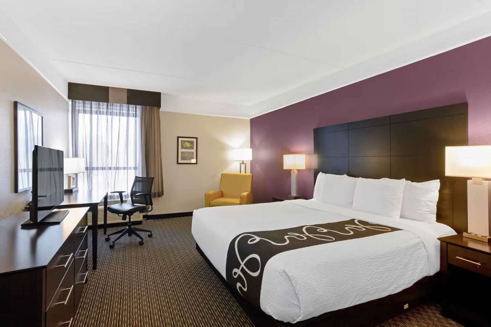 King bed room with work desk and chair by a sunlit window