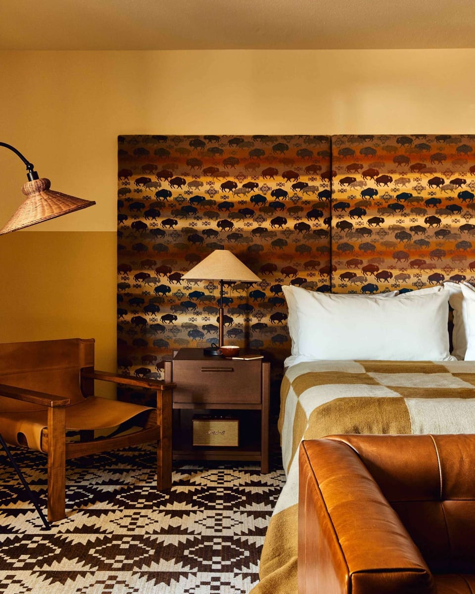 Bedside view with chair, lamp, table, and patterned headboard