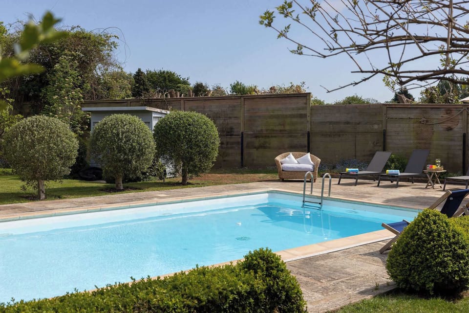 Heated outdoor pool surrounded by peaceful garden space.