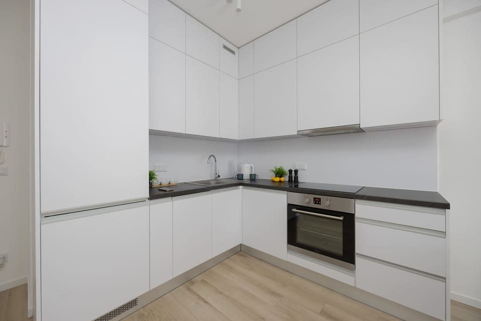Compact and stylish kitchen area equipped with essential appliances, including a dishwasher and washer-dryer.