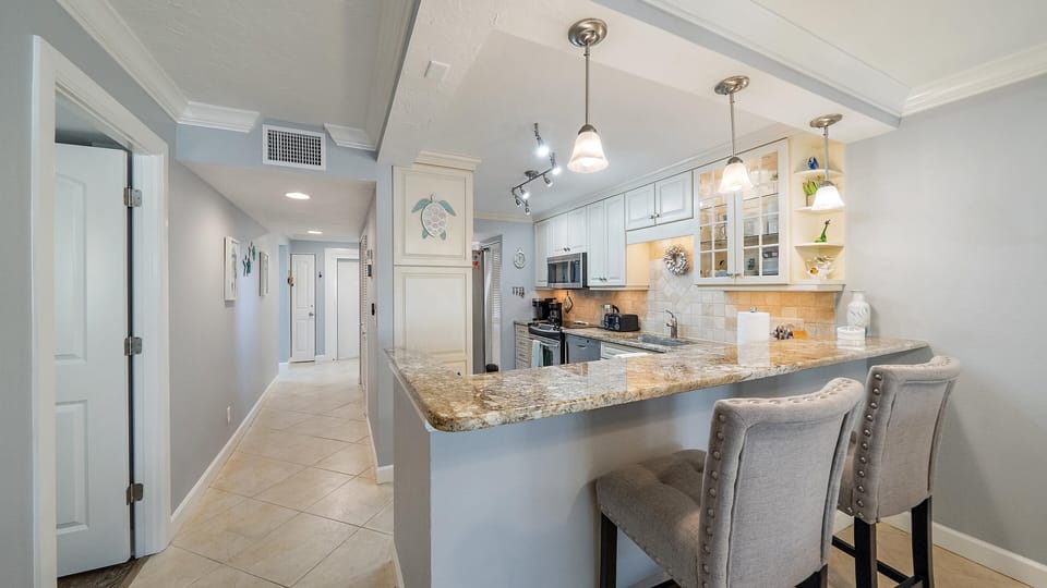 Cook, dine, and gather in your fully equipped kitchen featuring granite countertops, modern appliances, and a convenient breakfast bar where you can start your mornings with coffee.