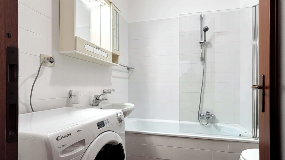 Moderno bagno con lavatrice.