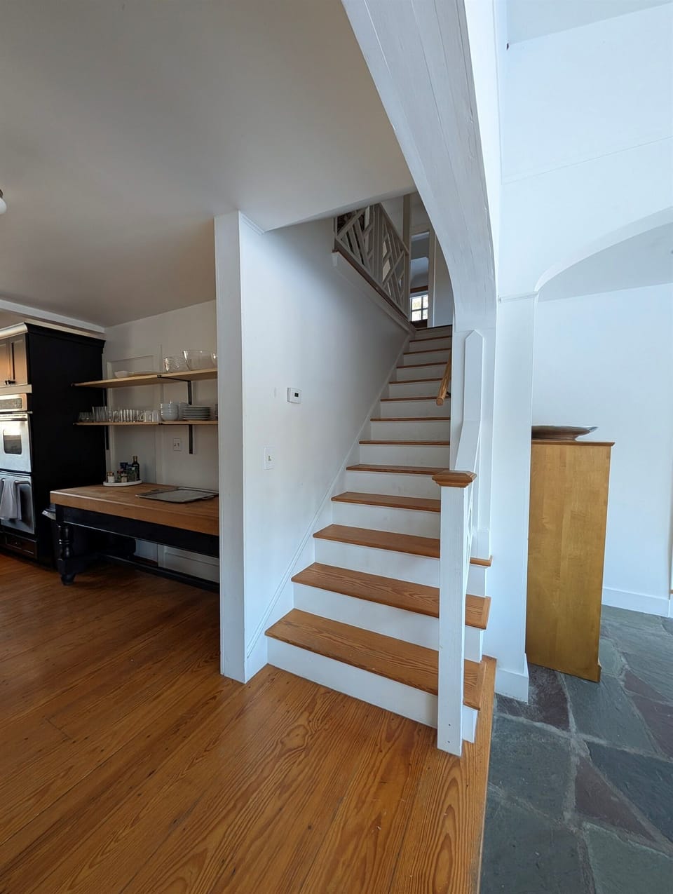 Graceful stairway with wood treads and traditional details, seamlessly integrated into the home’s open layout.