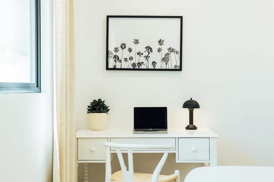 Bright and inviting workspace featuring a sleek white desk, modern task lamp, and plenty of natural light—perfect for remote work, studying, or journaling. 
