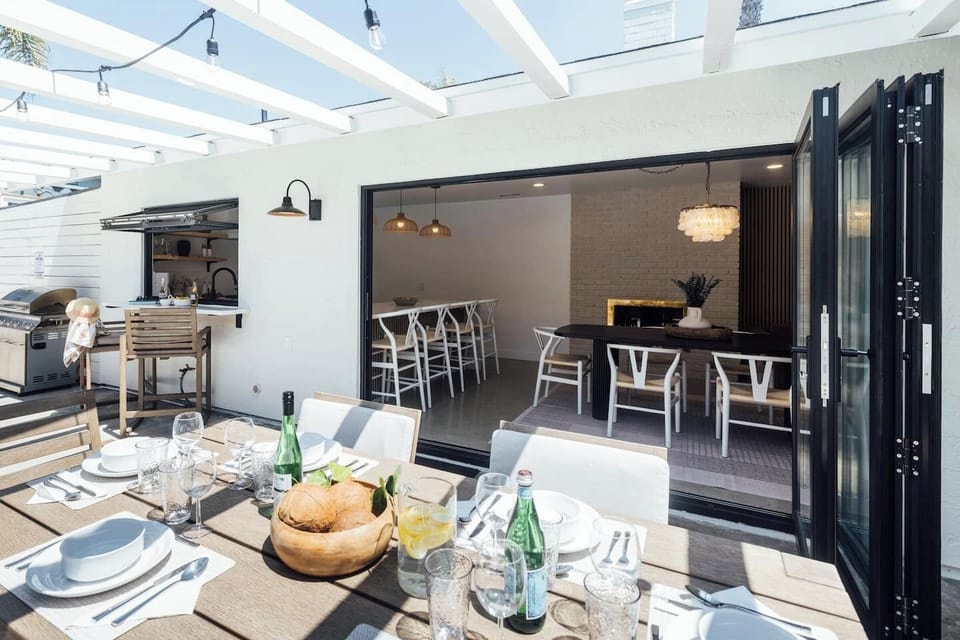The open-concept living room and kitchen seamlessly flow into the backyard through wide sliding doors, blending indoor comfort with outdoor relaxation for true SoCal living.