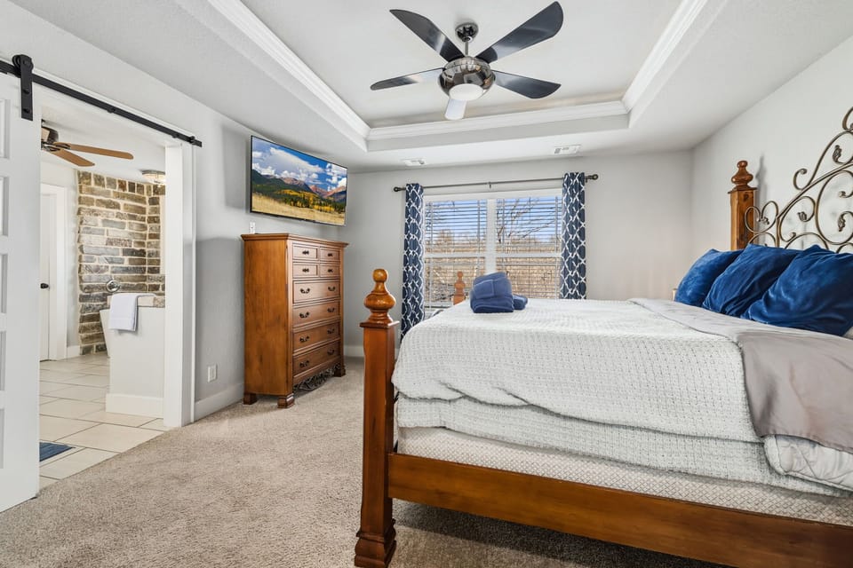 The primary bedroom is on the main floor and is complete with a King-size bed, a Smart TV, closet, and large en suite bathroom.