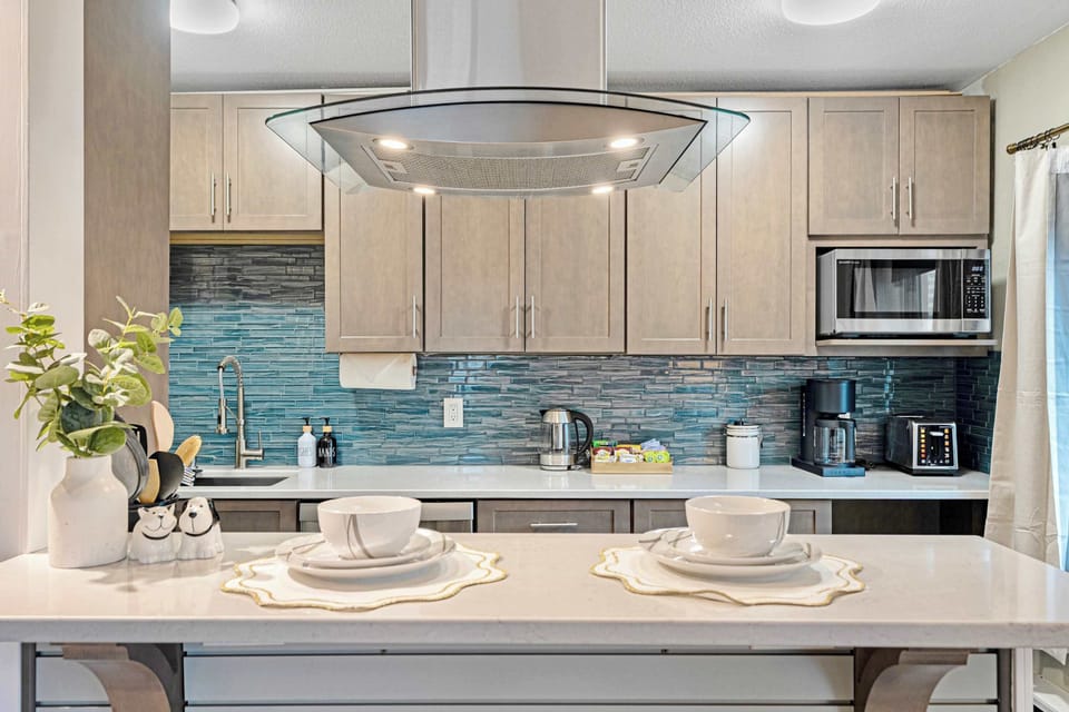Prepare a gourmet meal in the modern, fully-equipped kitchen featuring stainless steel appliances and a stylish tile backsplash.