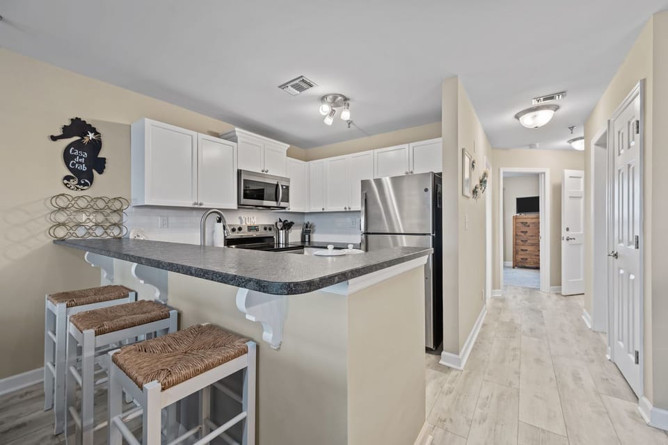 Fully equipped kitchen with stainless steel appliances and a convenient breakfast bar for casual dining