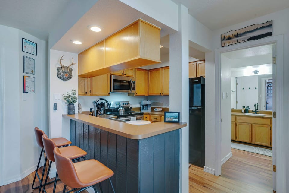 A fully equipped kitchen with stainless appliances, warm cabinetry, and everything needed for cooking in the mountains.