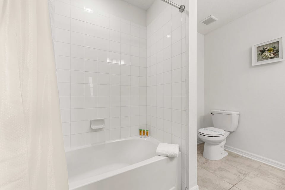 Bright, minimalist bathroom with a sparkling tub/shower combo-great for families. Fresh towels and toiletries included.